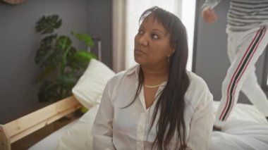 Gülümseyen bir çocuk, sıcak bir yatak odasında, neşeli bir anda gözlerini kapayarak annesini şaşırtır.