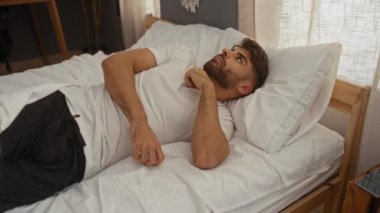 Genç adam rahat bir yatak odasında uyanıyor, güne rahat ve temiz bir şekilde başlıyor..