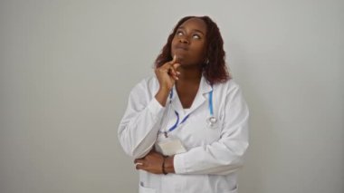 Doktor, üniformalı genç Afro-Amerikan kadın doktor, mutlu bir zaferi kutluyor kazanan bir gülümseme ve izole beyaz arka planda heyecanlı bir ifadeyle