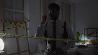 Afrika kökenli Amerikalı dedektifler kapalı alandaki olay yerinde telsizle uyarı bandı ve rozetle iletişim kuruyor..