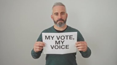 Beyaz bir duvara karşı demokratik bir slogan taşıyan sakallı bir adam..