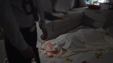 Dedektifin ofisindeki bir adam elinde bir silah tutuyor. Elinde kanıt ve olay yeri bandı var..