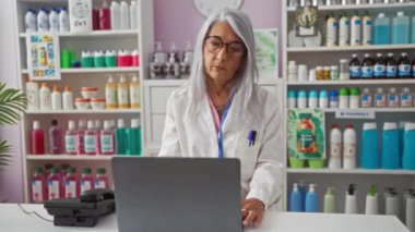 Kadın eczanede, içeride, laptopta çalışıyor, yaşlılar, kadınlar, profesyonel, eczane, gri saçlı, olgun, dükkan, iç mekan