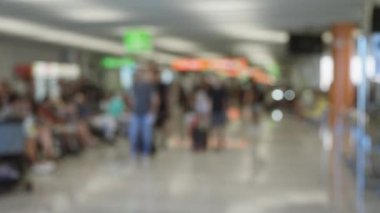 Bulanık gezginler hareketli bir havaalanı terminalinde renkli işaretlerle yürüyorlar.