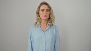 Kendine güveni tam genç sarışın bir kadın, gömlek giyiyor, beyaz izole arka planda duruyor. Ciddi bir görünüm sergiliyor, harika bir tarz ve samimi bir ifade sergiliyor..