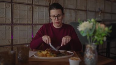 Genç bir İspanyol kadın, modern bir restoranda tek başına yemek yiyor. Günlük zarafet ve yaşam tarzı yayıyor..