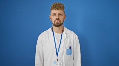 Sakallı, mavi gözlü, labaratuvar önlüğü ve halat takan yakışıklı bir genç..