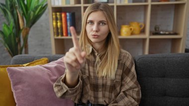 Genç, sarışın bir kadın, parmağını içeri sokup 