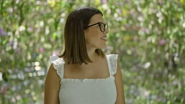 stock image Happy hispanic woman in glasses, an immersive exploration of futuristic plant exhibition at a colourful, modern museum