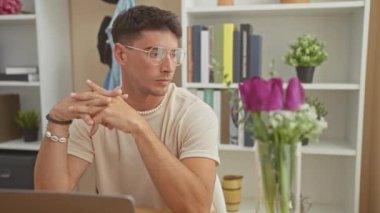 Ev ofisinde gözlüklü düşünceli bir adam modern ve temiz bir yaşam tarzı sergiliyor..