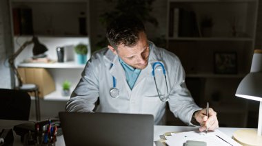 Gece klinikte steteskoplu yakışıklı İspanyol üniformalı bir adam not alıyor..