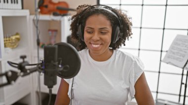 Afrikalı Amerikalı kadın müzik stüdyosunda şarkı söylüyor.