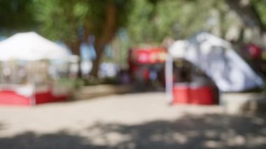 Bulanık insanlar Mallorca 'da bir açık markette yürüyorlar. Odaklanamayan ağaçlar ve yoğun arka planlar Bokeh etkisi yaratıyor..