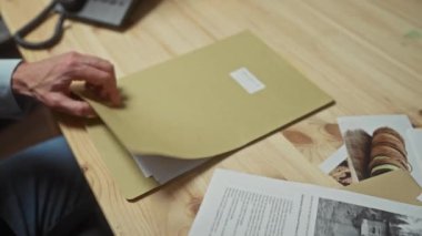 Bir adam soruşturma belgelerini ve raporlarını bir ofiste inceleyip dava analizini ima ediyor..