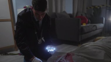 İspanyol bir dedektif loş bir odada büyüteçle suç mahallini inceliyor..