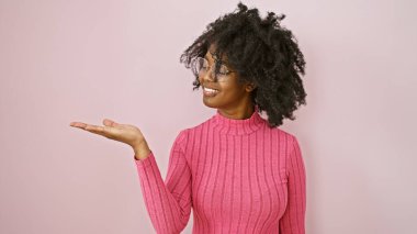 Pembe elbiseli gülümseyen Afrikalı kadın pembe arka planda, özgüven ve pozitifliği yansıtıyor..