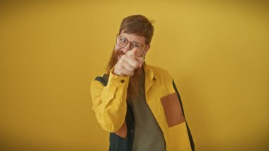 Sarı arka planda kameraya bakan sakallı yakışıklı kızıl saçlı adam..