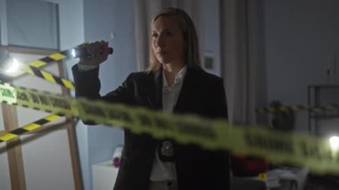 Fenerli odaklanmış dedektif kadın gece vakti olay yerini inceliyor.