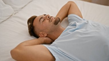 Sakallı yakışıklı, genç, İspanyol bir adam yatak odasında huzur içinde uyuyor.