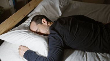 Geceleri loş bir odada huzur içinde uyuyan sakallı bir adam huzurlu bir ev atmosferini canlandırıyor..