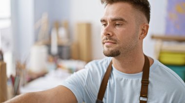 Stüdyoda sakallı yakışıklı genç adam yaratıcı ve düşünceli bir atmosfer sunuyor..