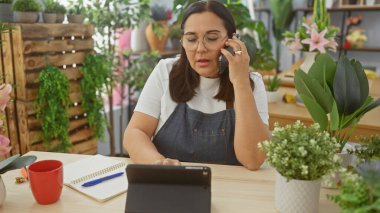 Çiçekçi dükkanında çiçeklerle çevrili İspanyol bir kadın iş yerindeki çiçekçiyi canlandırıyor..