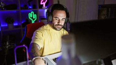 Modern neon ışıklı bir odada geceleri oynayan, dövmeli İspanyol bir adam..