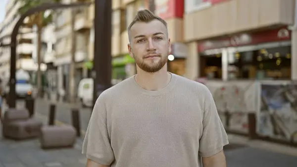 stock image Handsome bearded young man posing casually outdoors in an urban street setting.