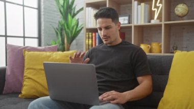 Sakallı genç bir İspanyol evde dizüstü bilgisayarla çalışırken kol ağrısı çekiyor. Teletıp danışmanlığı öneriyor..