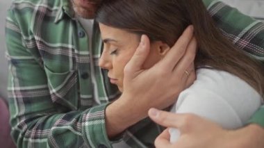 Kapalı mekanlarda kadınları rahatlatan, ev ortamında duygu ve destek sergileyen bir adamın yakın çekimi..