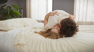 Sevgi dolu bir çift, sıcak bir yatak odası ortamında sıcak ve samimi bir anın tadını çıkarır..