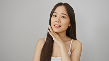 Beyaz bir arka planda zarif bir şekilde izole edilmiş genç, çekici Asyalı bir kadının portresi.