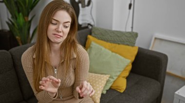 Kapalı bir koltukta oturan genç sarışın bir kadın iğrenç bir yüz ifadesi sergiliyor..