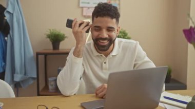 Sakallı, evinde akıllı telefon ve dizüstü bilgisayar kullanan neşeli, genç bir İspanyol. Rahatlık ve bağlantı yayıyor.