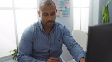 Ofisteki genç adam elinde bardak tutarken belge okuyor.