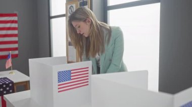 Nane takım elbiseli genç sarışın bir Amerikalı kadın oylarını evin içinde bayraklar arasına atıyor..