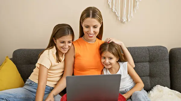 stock image Smiling woman with girls working on laptop in cozy living room