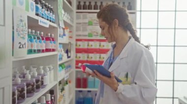 Eczanedeki ilaçlara bakarken tablet kullanan odaklanmış kadın eczacı