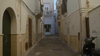 Gelibolu, puglia, İtalya 'da dar bir sokak, eski bir scooter ve tipik Akdeniz mimarisi ile balkonları ve yıpranmış binaları var..