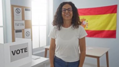 Kazanan! İspanya Seçim Koleji 'nde oy kullanan orta yaşlı İspanyol kadın, başarı için mutlu ve heyecanlı, sevinç ve zafer jesti çığlıkları atıyor.