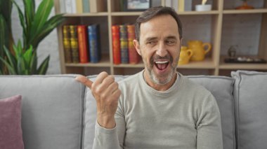 Kapalı bir koltukta otururken sakallı, neşeli, olgun bir adam..