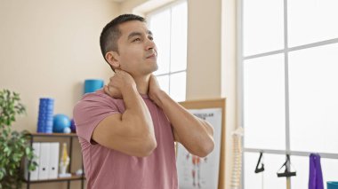 Modern ekipmanlarla fizyoterapi kliniğinde boyun esneten İspanyol bir adam.