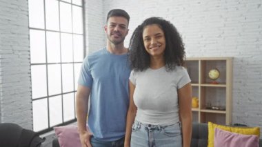 Neşeli bir adam ve kadın, sıcak, aydınlık bir oturma odasında kucaklaşıyorlar, sevgi ve beraberlik yayıyorlar..