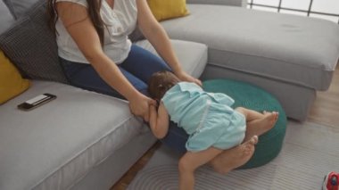 Küçük kızıyla sıcak bir oturma odasında bağ kuran bir kadın aile sevgisini ve mutluluğunu resmediyor.