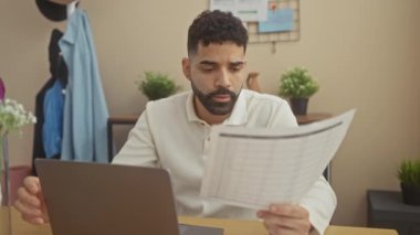 Konsantre olmuş genç bir İspanyol yurt içi ofisinde mali belgeleri inceliyor..