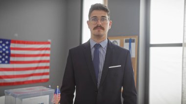 Yakışıklı İspanyol takım elbiseli adam oy sandığıyla bir seçim odasında duruyor ve biz de demokrasiyi temsil ediyoruz..