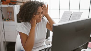 Kapalı mekanda bilgisayarla çalışan örgülü Afrikalı Amerikalı kadın.