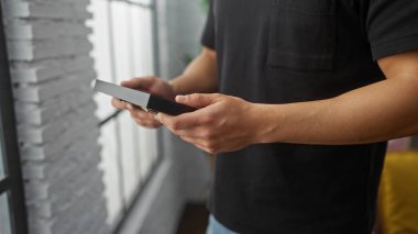 Bir evde odaklanmış ve merakla fotoğrafı inceleyen genç bir İspanyol..