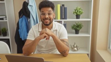 Memleketinde dizüstü bilgisayar kullanan neşeli Afro-Amerikalı adam, mutlu, açık ağızlı bir gülümsemeyle başparmağını kaldırıyor.