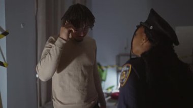 Kadın bir polis memuruyla gergin bir tartışma içinde olan erkek bir sivil, muhtemelen bir suç mahallinde..